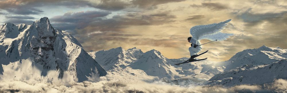 Sommets au-dessus d’une mer de nuages, avec un skieur